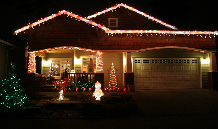 Family home illuminated with Christmas decorations and lights during the night.